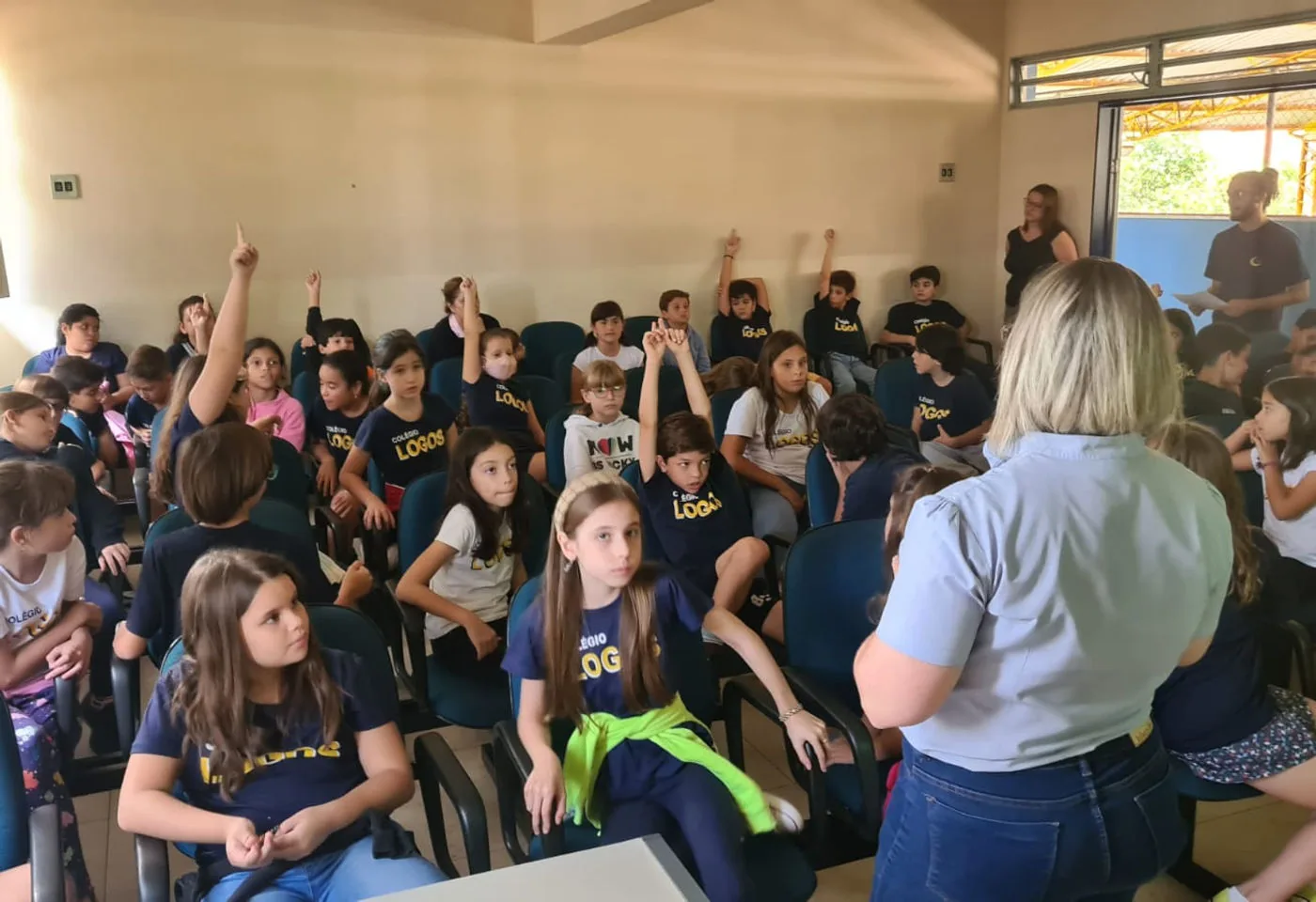 Michelle falando para uma plateia de estudantes em uma escola