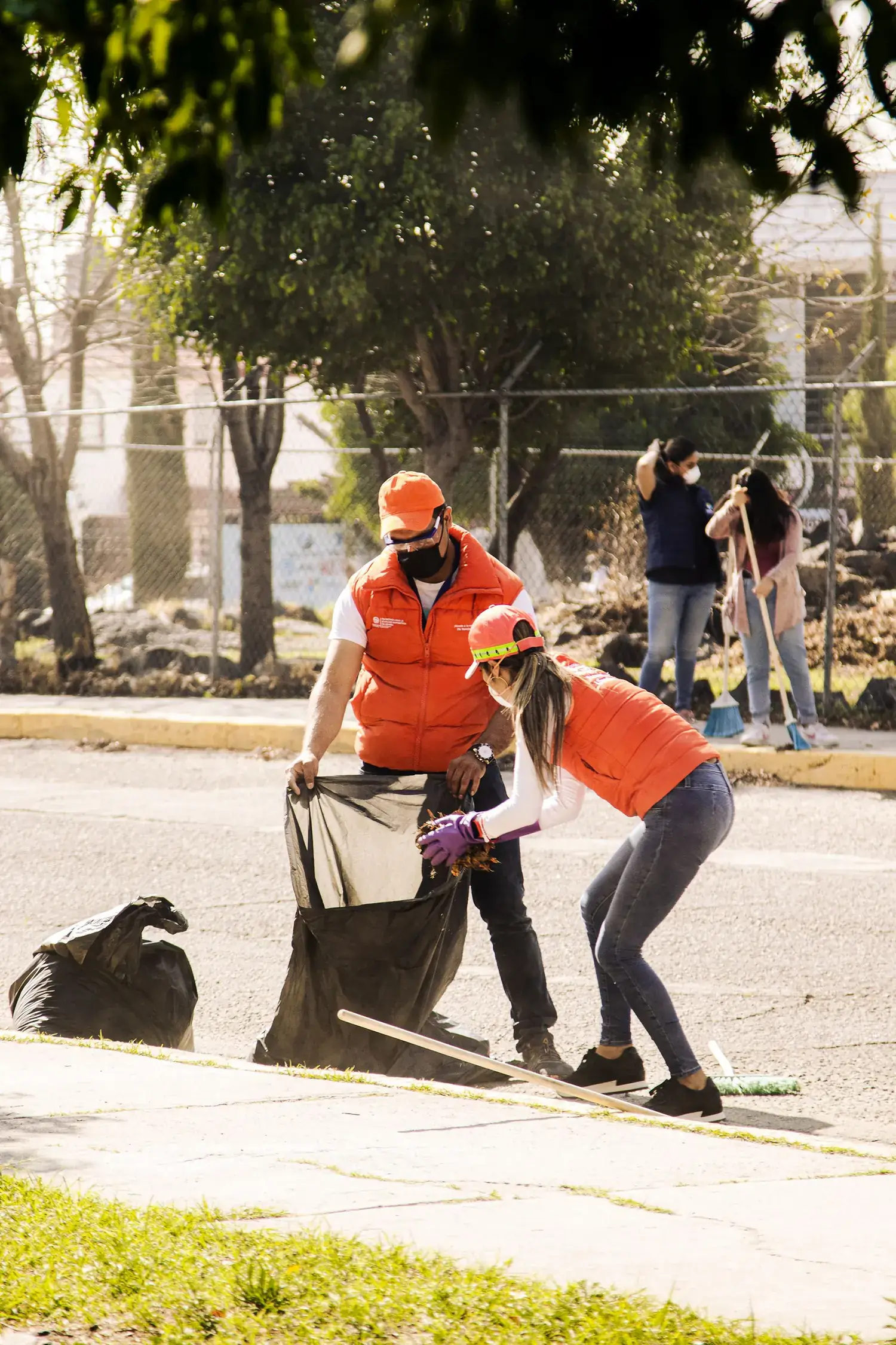 Voluntários recolhendo resíduos em um mutirão de limpeza na rua